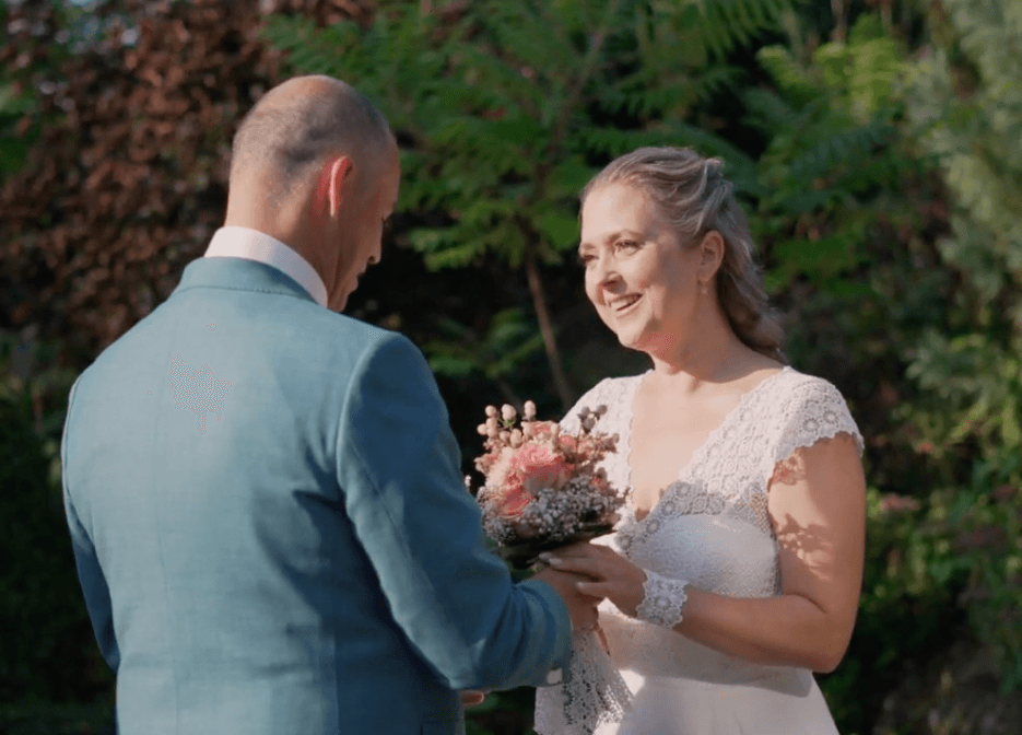 Bruidspaar met boeket tijdens de ceremonie