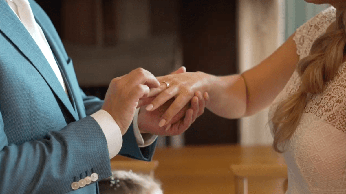 Bruidegom schuift de ring om de vinger van de bruid